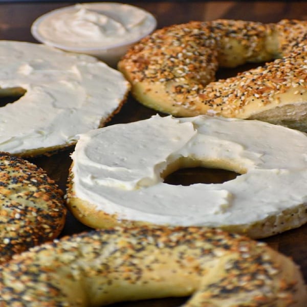 Bagel Nosh bagels, some with everything seasoning, some with cream cheese, and a side of cream cheese.